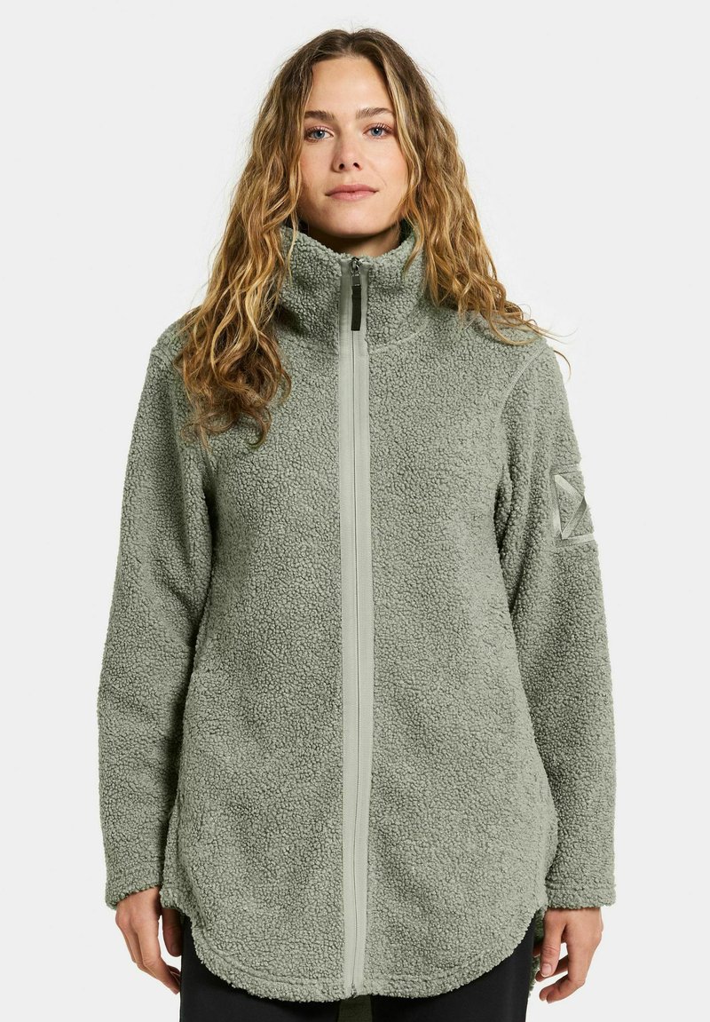 Fleecejacka i dämpad grön färg med hög krage, full dragkedja framtill och strukturerad yta. Har sidofickor och en logopatch på sidan.