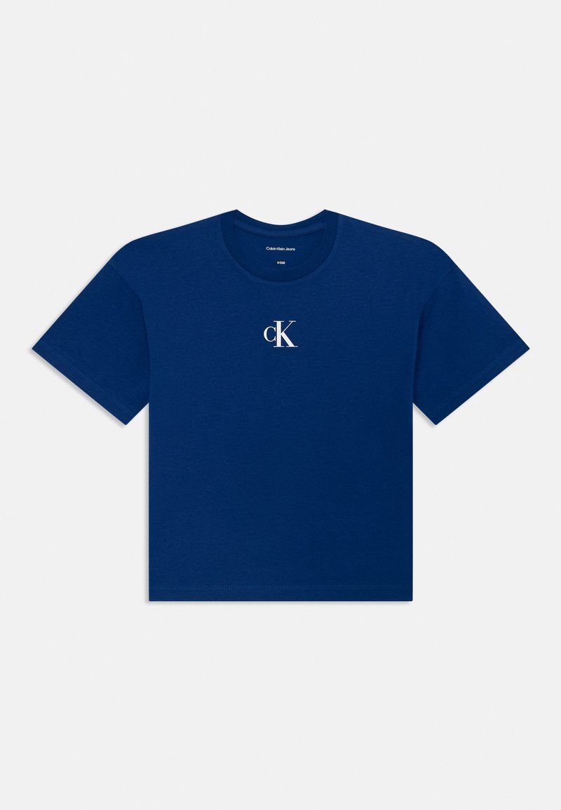 Tums zils kokvilnas T-krekls ar īsām piedurknēm, apaļu kakla izgriezumu un mazu baltu "cK" logotipu priekšpusē. Gluda tekstūra, standarta piegriezums.