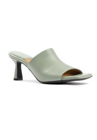 Mule verde in pelle aperta davanti, con una superficie liscia, un design curvo nella parte superiore e un tacco a blocco nero. Presenta uno stile minimalista.