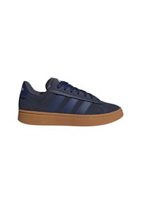 Baskets Adidas bleu marine avec trois bandes bleu plus foncé, semelle en caoutchouc couleur gomme, col rembourré et lacets, sur fond blanc.