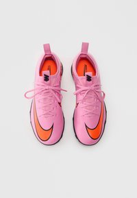Et par rosa treningssko med oransje swoosh-logoer, rosa snører og svarte såler på hvit bakgrunn.