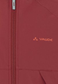 Giacca softshell rossa con zipper centrale e un semplice logo arancione. Texture liscia con dettagli di cucitura sottili.