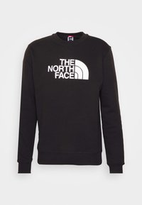 Sweat-shirt noir à manches longues avec col rond, logo blanc "The North Face" centré sur la poitrine.