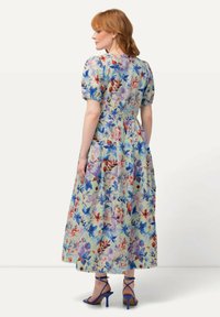 Květinové maxi šaty s krátkými puff rukávy, přiléhavým korzetem a plnou sukní. Materiál je lehký s vícolorovým květinovým potiskem.