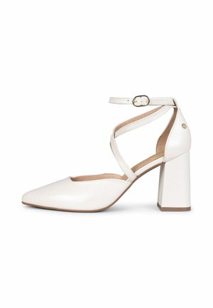 Zapato de tacón alto de cuero blanco con punta puntiaguda, tacón grueso y correas cruzadas en el tobillo con cierre de hebilla pequeña.
