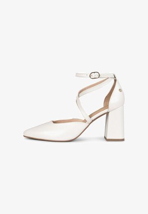 Zapato de tacón alto de cuero blanco con punta puntiaguda, tacón grueso y correas cruzadas en el tobillo con cierre de hebilla pequeña.