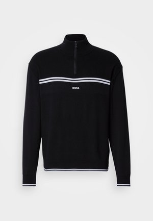 Pull noir avec un col montant, doté d'une fermeture éclair. Rayures horizontales blanches sur la poitrine et logo blanc centré en dessous.