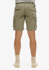 Khaki cargoshorts met meerdere zakken, een aansluitende taille en een rechte snit. Kenmerken zijn onder andere stiksels en een licht ruwe textuur.