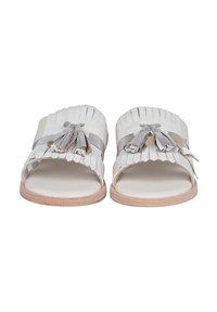 Sandali piatti senza chiusura in pelle grigia chiara con un design a frange a strati e nappine decorative. Suola in tonalità legno naturale. Stile open-toe.