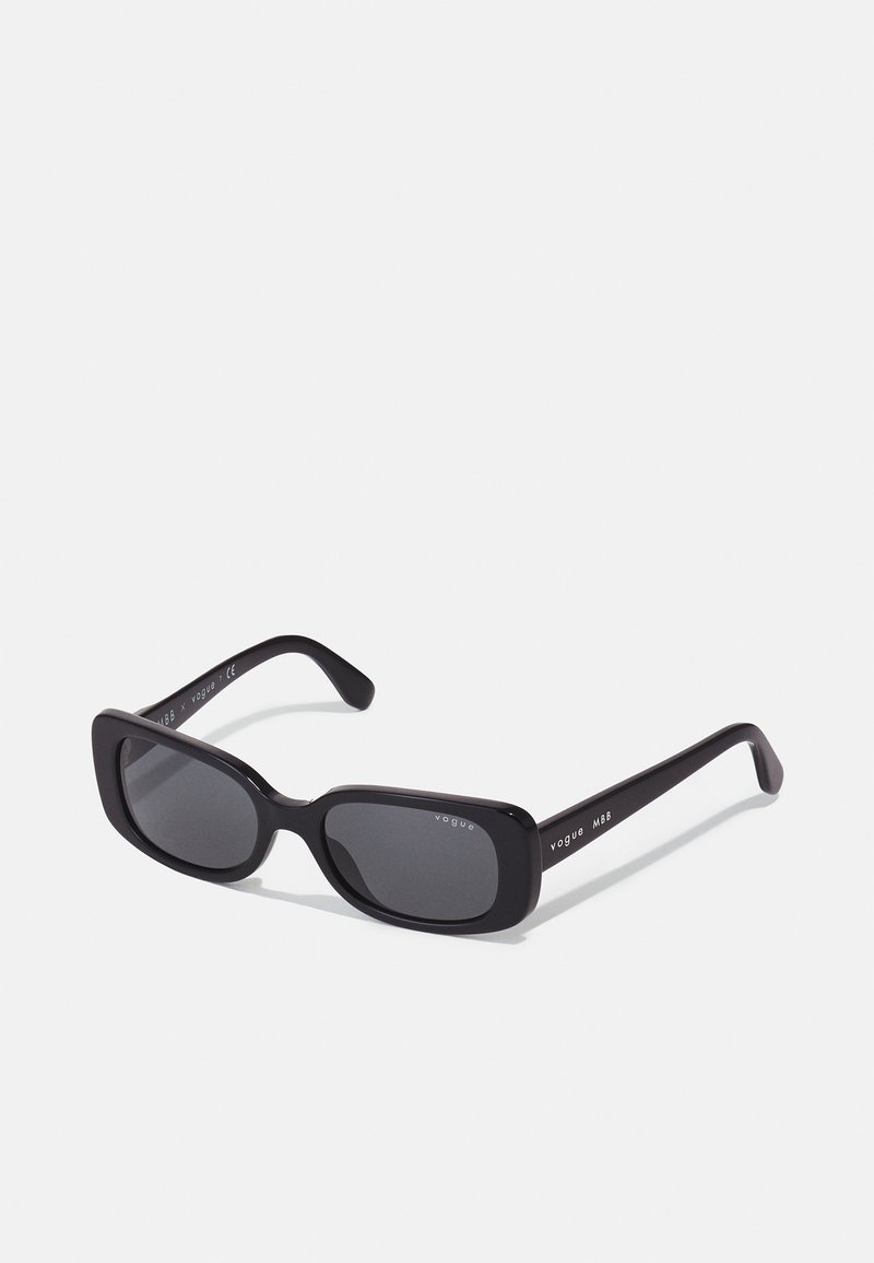 Óculos de sol retangulares pretos com lentes escuras, armação de plástico elegante e um logótipo discreto na haste. Acabamento suave e design minimalista.