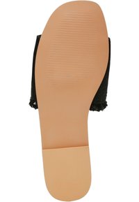 Sandal nera con upper testurizzato, suola piatta in gomma beige chiaro con righe orizzontali per una migliore aderenza. Design aperto sul retro.