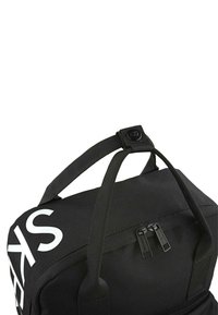 Bolsa de deporte negra con asas superiores reforzadas, que cuenta con un cierre con cremallera y una gran letra blanca en el lateral. Tejido texturizado.