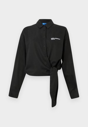 Schwarzes Langarmshirt mit Kragen, vorne gebunden. Hergestellt aus glattem Stoff mit einem gestickten Logo auf der linken Brust.