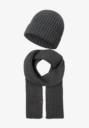 Ensemble bonnet et écharpe en tricot côtelé gris foncé. L'écharpe est longue et s'enroule avec une petite étiquette en cuir brun, le tout fabriqué en tissu doux.