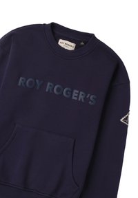 Granatowy sweter z okrągłym dekoltem, kieszenią z przodu i wyraźnym napisem "ROY ROGER’S" w ciemniejszym odcieniu. Posiada dekoracyjną naszywkę na rękawie.