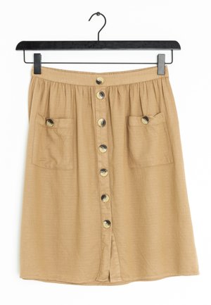 Gonna di lino beige con vita elastica, chiusura frontale a bottoni, due tasche laterali e orlo dritto. Presenta bottoni in tonalità ottone.