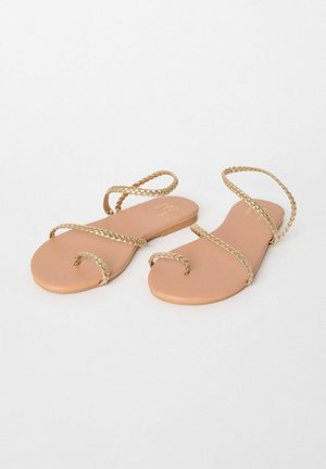 Flache Sandalen in Tan mit geflochtenen Goldriemen, einfache Sohlengestaltung, offene Zehen und minimalistisches Design.