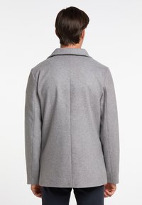 Palton dintr-un amestec de lână gri, cu un design structurat, rever larg și o fanta unică în spate, având o textură netedă.