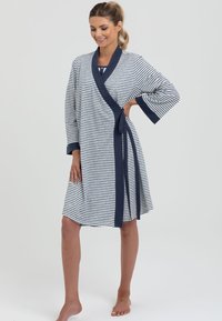 Pasiasty szlafrok w granatowo-białym kolorze, z rękawami o długości trzy czwarte, zapinany na przewiązanie z paskiem w talii. Miękka tekstura.