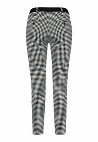 Pantalon slim à motif pied-de-poule noir et blanc avec ceinture noire et deux poches arrière boutonnées, vu de dos.