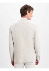 Licht beige linnen blazer met een gesneden kraag, sluiting met twee knopen en lange mouwen. Fijne structuur en een getailleerde pasvorm, met nette lijnen.