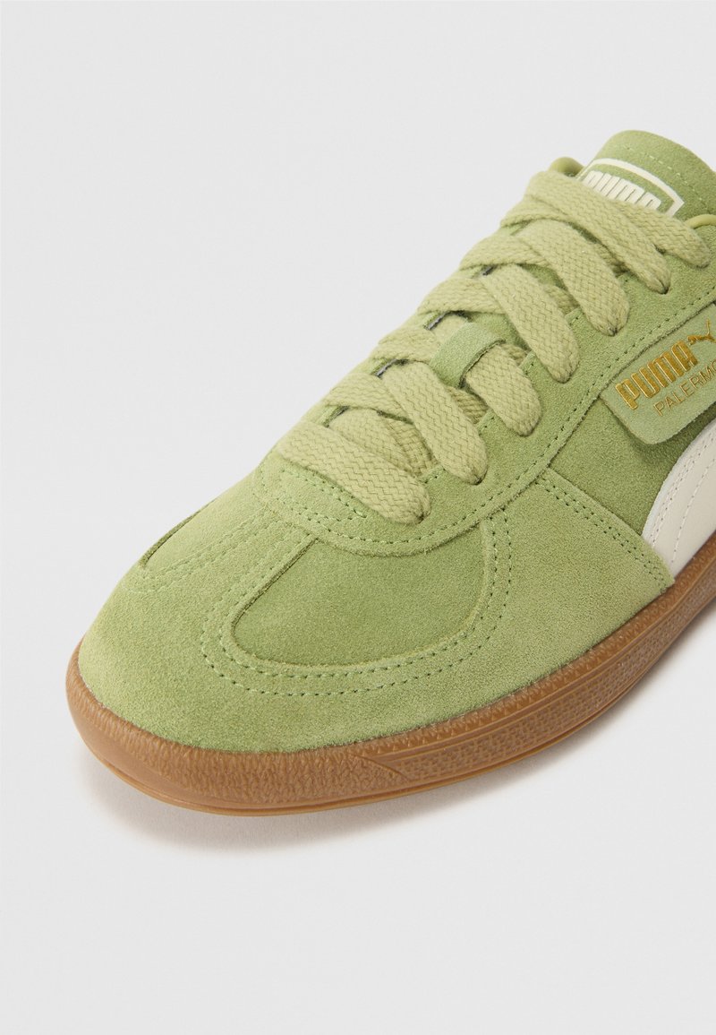 Sneaker verde scamosciato con punta tonda, suola in gomma testurizzata, chiusura con lacci e un pannello laterale bianco con marchio in tonalità oro.