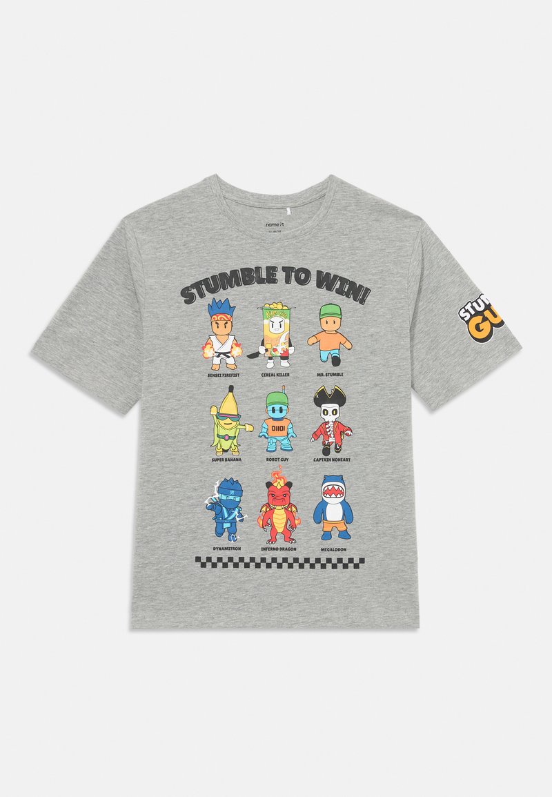 Camiseta gris con personajes de dibujos animados y nombres organizados en una cuadrícula de 3x3, con el texto "¡Tropezar para ganar!" en la parte frontal y un logo en la manga.