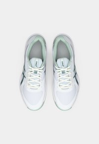 White athletic shoes with mint green accents, mesh and synthetic upper, round toe, lace-up design, and distinct logo on tongue.