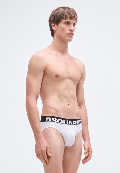 Calzoncillos blancos para hombre con una cintura negra de "DSQUARED2", hechos de un material suave, con un ajuste ceñido y diseño sin costuras.