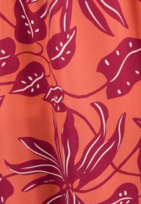 Rood-oranje stof met een tropisch bladerenpatroon in diep bordeauxrood met witte accenten, met een gladde textuur en complexe details.