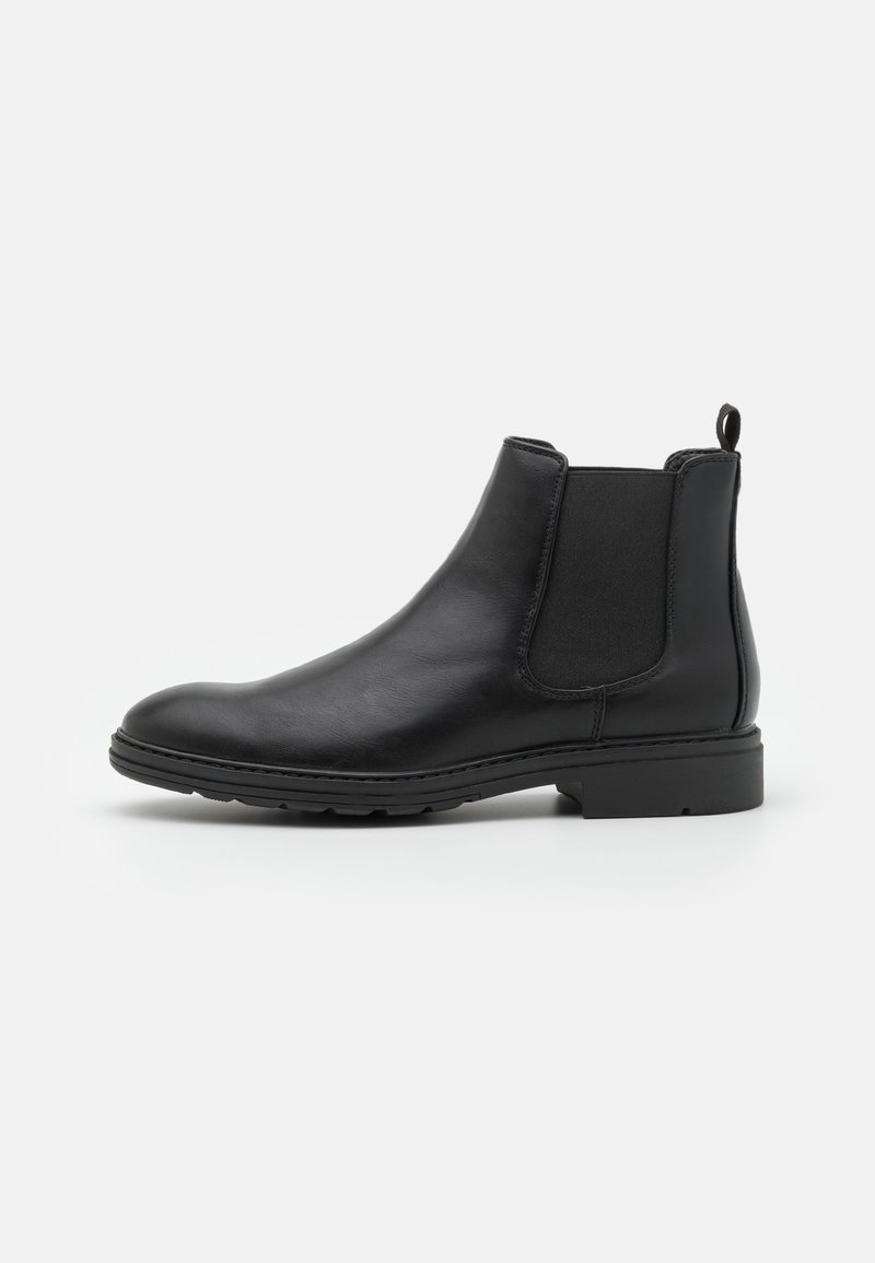 Stivale Chelsea in pelle nera con pannelli laterali elasticizzati e un ciondolo sul tallone, caratterizzato da una punta arrotondata e una suola in gomma testurizzata.