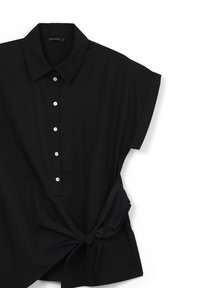 Maglietta nera con colletto, dotata di bottoni in tessuto, maniche corte e dettaglio annodato in vita. Texture morbida e vestibilità rilassata.