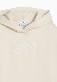 Crèmfarget hettegenser med en stor hvit brodert "Puma"-logo på forsiden, med snøring på hetta og en myk tekstur.