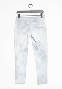 Ljust grå sweatpants med ett tie-dye mönster, tillverkade av mjukt material. Har två bakfickor och en liten vit logotyp på höger ficka.