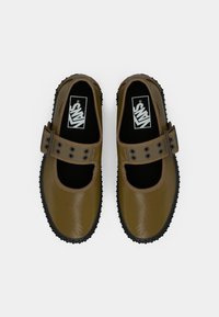 Pruunid nahast Mary Jane stiilis kingad pandlaga rihmaga, musta kummist tallaga ja siledapinnalised. Taldedel nähtav logo.