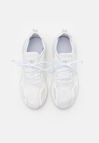 Vita sportskor med mesh-övre, snören och texturerade sidpaneler. Har subtil branding och vadderad krage.