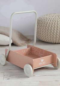 Pink metal pushvogn med et lyst gråt håndtag og hjul. Indre design har hvide illustrationer af skyer og stjerner. Mærkevaren "MICKI" er synlig.