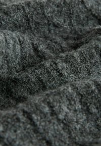 Texturovaná tmavě šedá tkanina s měkkým, chlupatým povrchem. Vyznačuje se zvlněným vzhledem, který ukazuje různé hloubky a vlákna.