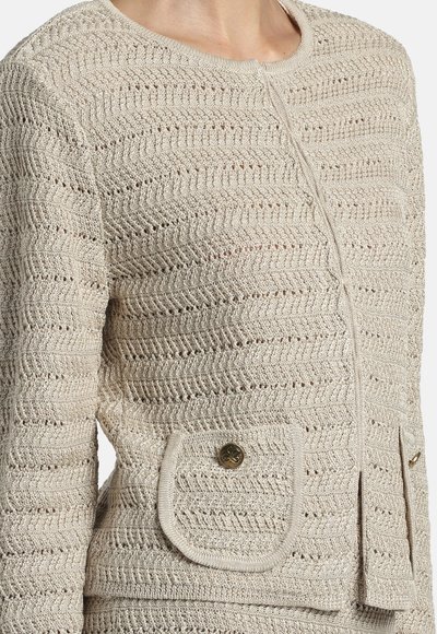 Cardigan bej tricotat cu model zigzag, decolteu rotund, mâneci lungi și buzunare cu clape cu nasturi decorativi.