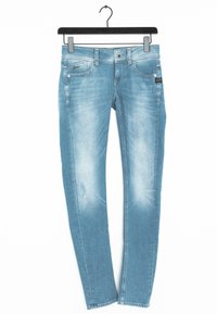 Ljust blå denimjeans med slim fit, med en urtvättad textur, små framfickor och en svart etikett på midjebandet.