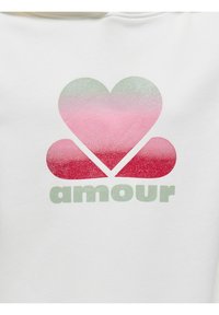 Felpa bianca con un design a cuore in gradiente rosa e verde e dettagli glitterati, con la scritta "amour" in verde chiaro in basso.