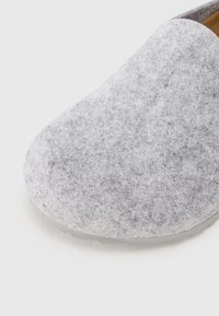 Grå, slip-on sko med avrundet tå, myk tekstur og minimalistisk design. Har såle i lys grå gummi.