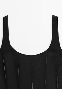 Black dress with wide shoulder straps, featuring a rounded neckline and vertical seam detailing for texture. Made from a smooth, lightweight fabric.