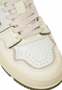 Sneakers in pelle liscia bianca, con punta perforata, lacci rosa, dettagli grigi e suola in gomma olivastro testurizzata. Design arrotondato.