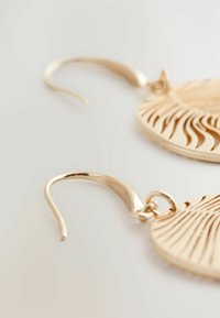 Goldfarbene Ohrringe mit einem strukturierten, elongated Blattdesign. Verfügen über gebogene Haken und filigrane Aussparungen entlang der Oberfläche.