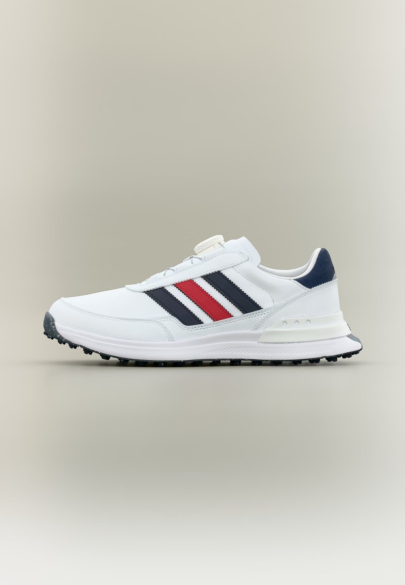 White low-top sneaker with black, red, and navy stripes, black textured sole, and navy heel tab, shown in side profile on neutral background.