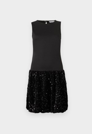 Ujjatlan fekete ruha, amelynek felső része testhez simul, a szoknyarésze pedig rövid és fényes fekete flitterekkel borított, sima fehér háttér előtt.