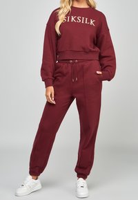Chándal burdeos de tejido suave, con sudadera corta que lleva el logo "SIKSILK" y pantalones con cintura elástica a juego, que tienen bolsillos laterales.
