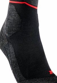 Calza sportiva nera con tallone e supporto alla caviglia grigi testurizzati, con una striscia di accento rossa nella parte superiore e un corpo completamente nero.