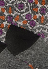 Tessuto con una base grigia e un motivo floreale in viola, arancione e bianco. Un bordo di stoffa nera è visibile lungo il fondo.